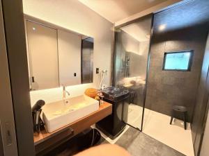 a bathroom with a sink and a large mirror at 奄美 Palm Tree Terrace in Ōkachi +15 photos