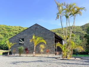 a black house with palm trees in front of it at 奄美 Palm Tree Terrace in Ōkachi