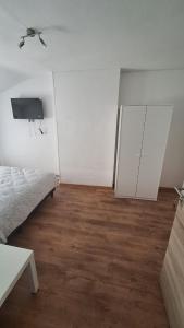 a white room with a bed and a ceiling fan at Residence La Fafa in Charleroi