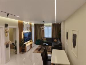 a living room with a couch and a table at SSS Luxury Apartment with Jacuzzi in Kamëz