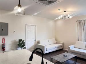 a living room with a white couch and a table at Executive 1BR Downtown POS with ensuite bath in Port-of-Spain
