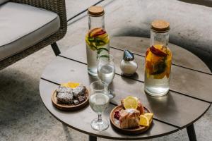 a table with two plates of food and two bottles and glasses at Hotel Porto Tara in Žabljak