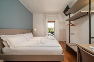 a hotel room with two beds and a table at Ventus Park Hotel in Nago-Torbole