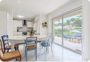 a kitchen and dining room with a table and chairs at Villa Osher in Saint-Raphaël