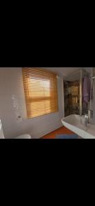 a bathroom with a window with a sink and a tub at Entire flat with 2 separate rooms in Norwood
