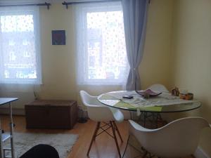 a table and chairs in a room with two windows at Entire flat with 2 separate rooms in Norwood