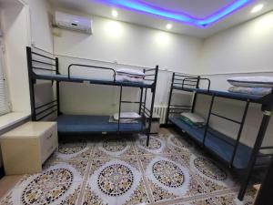 a room with three bunk beds in a room at Bobo Haydar FREE LONDRY SERVICE in Bukhara +1 photo
