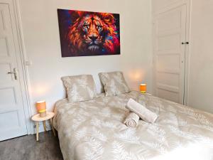 a bedroom with a bed with a painting on the wall at Maison chaleureuse - Proche du lac in Tresserves