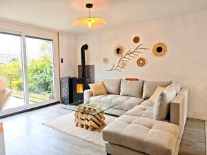 a living room with a couch and a glass table at Maison chaleureuse - Proche du lac in Tresserves +23 photos