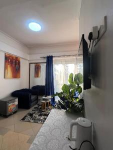 a living room with a blue couch and a living room at Vine Gardens & Hotel, Mityana in Mityana