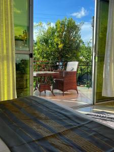 a room with a bed and a balcony with a chair at Vine Gardens & Hotel, Mityana in Mityana