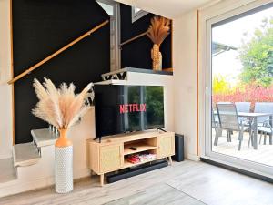 a living room with a tv on a stand at Maison chaleureuse - Proche du lac in Tresserves