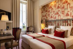 a hotel room with two beds and a desk at Arioso in Paris +76 photos