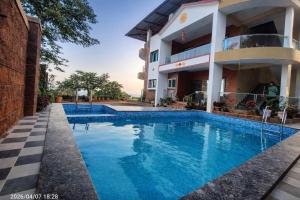 a swimming pool in front of a building at Jayarutu Bungalow Mahabaleshwar in Mahabaleshwar