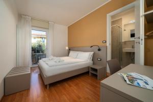 a small room with a bed and a table at Ventus Park Hotel in Nago-Torbole