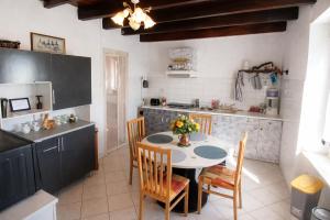 a kitchen with a table and chairs in a kitchen at location Vakañsoù in Lanouée