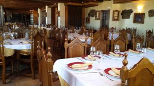 a dining room with tables and chairs with plates of food at Hostal Rural Jarpar in Grajera