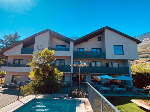 a building with a pool and a resort at Hotel Garni Vinea Montis in Termeno