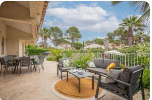a patio with a couch and chairs and a table at Villa Osher in Saint-Raphaël
