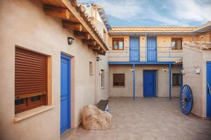 a courtyard of a building with blue doors at Casa Rural La Posada del Quijote in Puerto Lápice