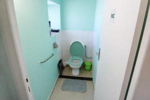 a bathroom with a toilet with a green seat at location Vakañsoù in Lanouée