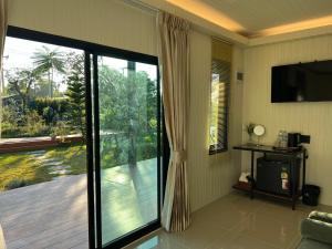 a living room with a sliding glass door to a deck at SafeHouse resort เซฟเฮ้าท์รีสอร์ท in Ban Laem Phai