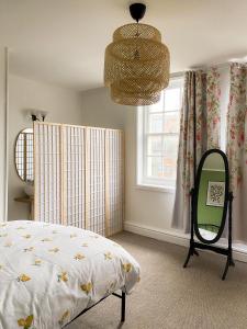 a bedroom with a bed and a mirror and a window at Cozy en suite room in King's Lynn