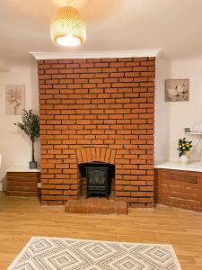 a brick wall with a fireplace in a living room at Cozy en suite room in King's Lynn