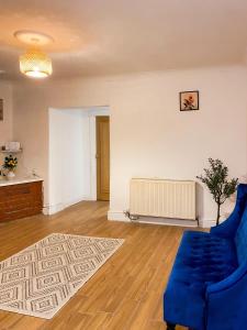 a living room with a blue couch and a radiator at Cozy en suite room in King's Lynn +2 photos