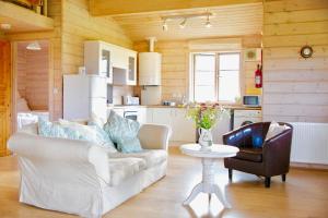 a living room with a couch and a table and a kitchen at Curlew Lodge in Dumfries