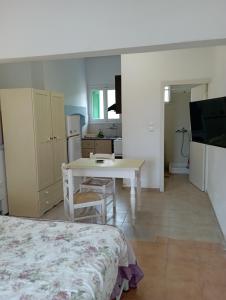 a room with a bed and a table and a kitchen at Paradisos Studios in Pyrgi Thermis