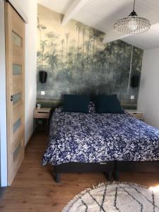 a bedroom with a bed and a painting on the wall at Maison de ville proche mer in Les Sables-d'Olonne