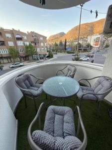a patio with a table and chairs and a street at Apartment ANIIDA in Mostar