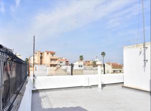 a white fence next to a white wall with buildings at Lo Racó del Delta in Sant Jaume d'Enveja