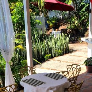 a table and chairs and an umbrella on a patio at Hotel suites Las Abuelas in Copán Ruinas