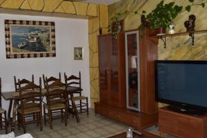 a living room with a television and a dining table at Lo Racó del Delta in Sant Jaume d'Enveja