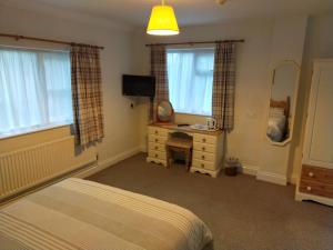 a bedroom with a bed and a desk and a mirror at The Green Dragon Inn in Redditch
