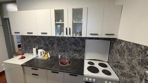 a kitchen with white cabinets and a stove at Apartment ANIIDA in Mostar