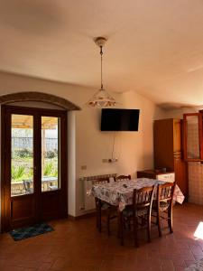 a dining room with a table with chairs and a television at Da Davide in Marciana Marina
