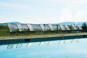 a row of chairs sitting next to a swimming pool at TrappHof in Stowe Fork