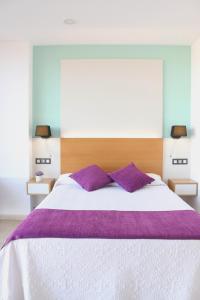 a bedroom with a large bed with purple pillows at Hotel La Noyesa *** Superior in O Grove