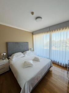 a bedroom with a large white bed and a window at Darkin 10 in Strožanac