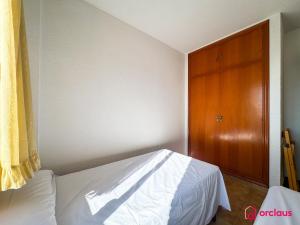 a bedroom with a bed and a wooden cabinet at Poble Mar 7 in Oropesa del Mar +47 photos