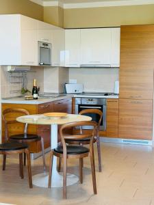 a kitchen with a table and chairs and a kitchen with white cabinets at Darkin 10 in Strožanac