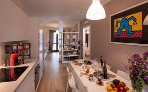 a kitchen with a long white table in a room at Casa Valentin in Monforte dʼAlba +25 photos