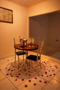 a table and chairs with wine glasses on a floor at Classik Prime Motel in Araçatuba