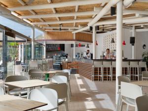 a restaurant with tables and chairs and a bar at H10 Suites Lanzarote Gardens in Costa Teguise