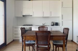 a kitchen with a wooden table and chairs at Sarnico Terrazza sul lago di Iseo in Sarnico