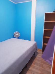 a bedroom with a bed and a blue wall at Duplex 2 quartos pertinho da Praia in Tramandaí