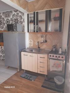 a kitchen with a sink and a refrigerator at Duplex 2 quartos pertinho da Praia in Tramandaí